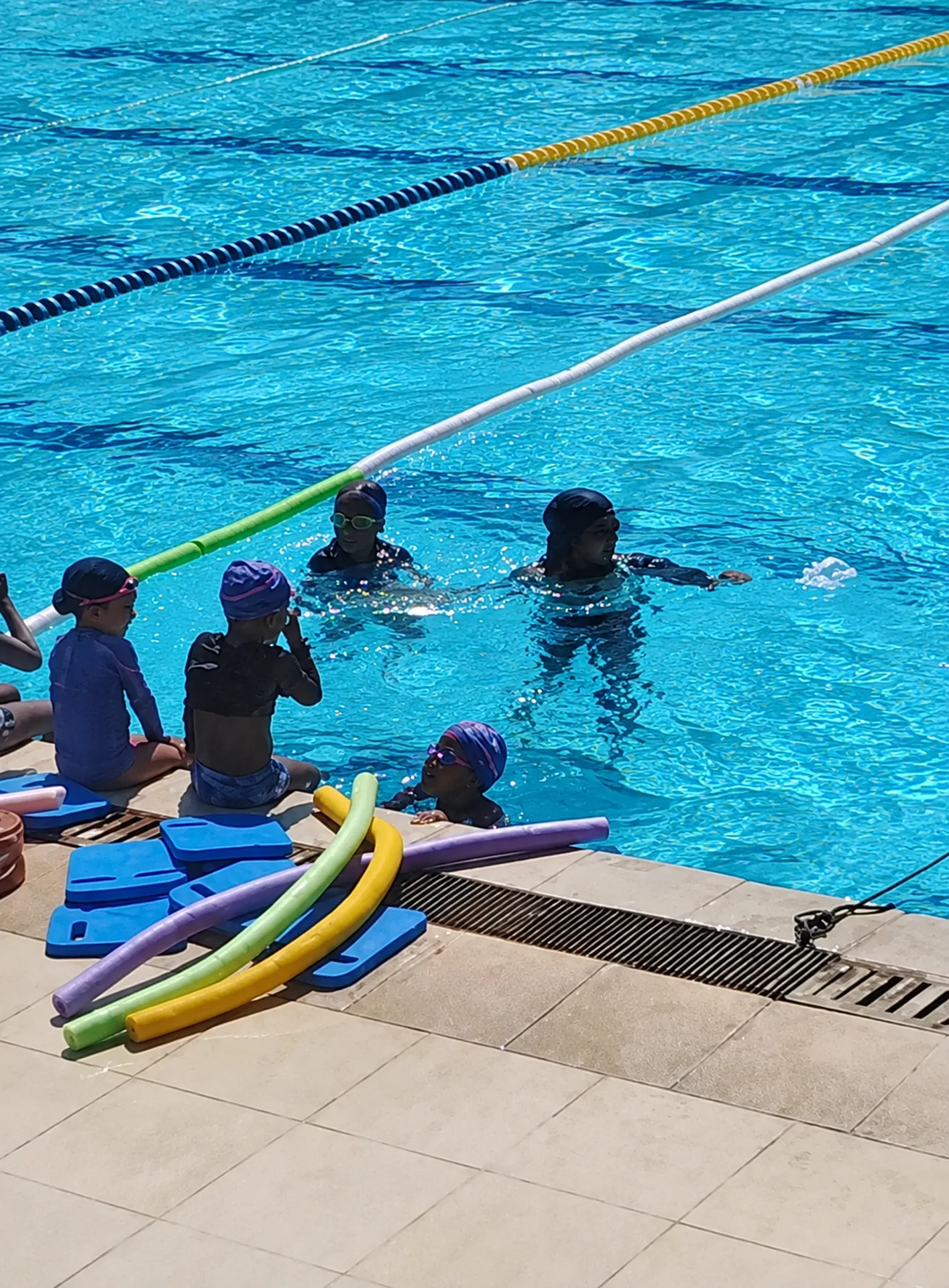 AQUACOAST children’s swimming class with learning equipment in a pool